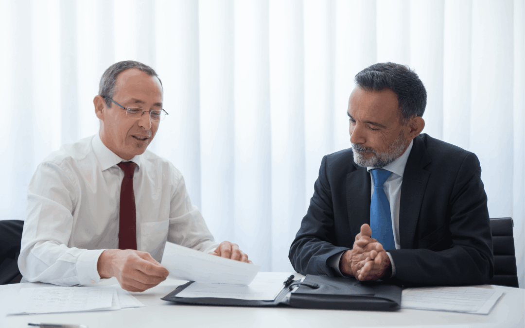 A business seller and potential buyer are deep in discussion as they negotiate the sale of a business.